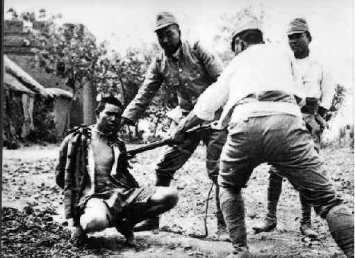 Soldados japoneses matando con una bayoneta a un prisionero chino atado