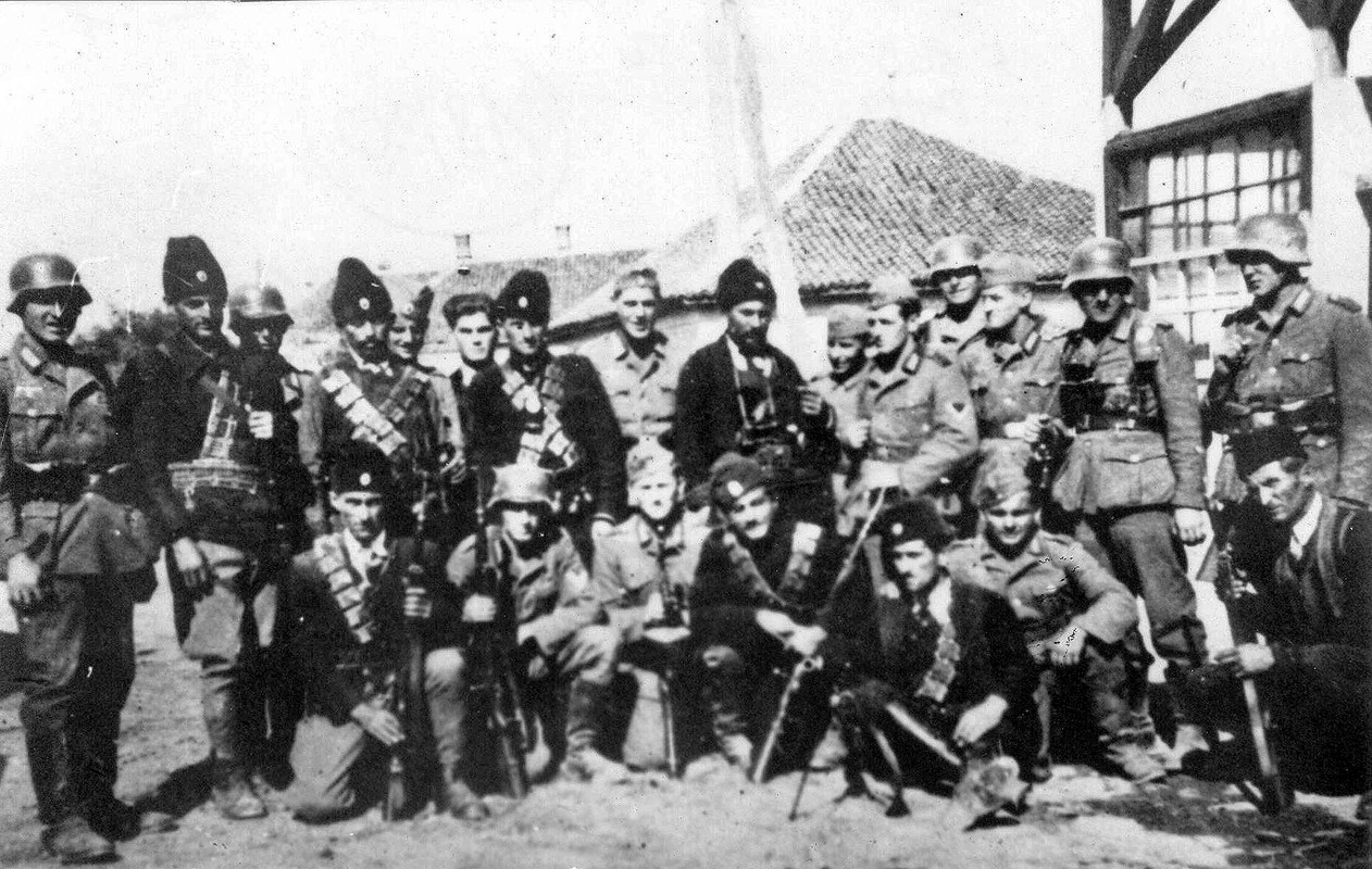Soldados alemanes y Chetniks posando juntos en una zona montañosa de Yugoslavia