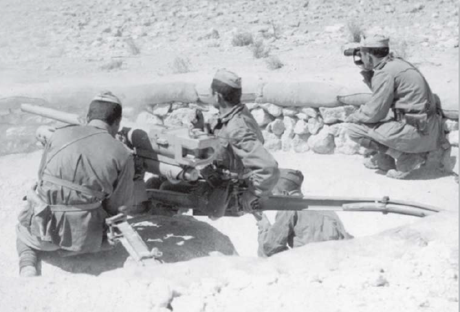 Artilleros italianos en una posición semicircular protegida por sacos de arena, manejando un antitanque M35 de 47 mm