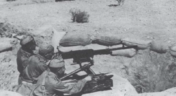 Soldados manejando una ametralladora Breda 37 de 8 mm en una trinchera en el desierto tunecino